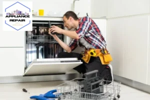 worker repairing dishwasher in the kitchen