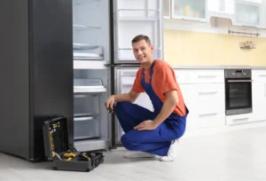 male tech repairing refrigerator